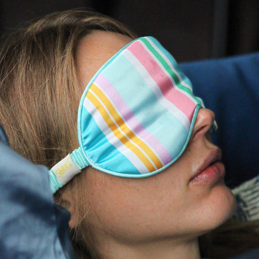 Woman wearing sleep mask, trying to sleep.