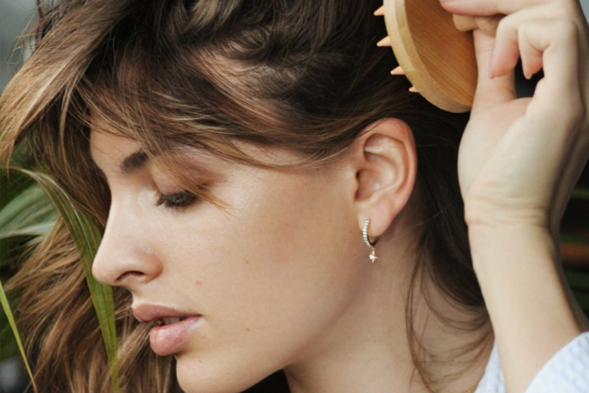 Woman using SMUG's bamboo scalp massager